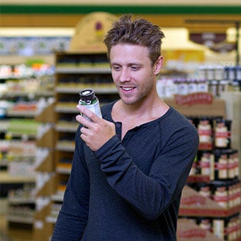 A man reads the label on a bottle of supplements.