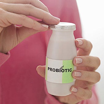 A person opens a probiotic drink bottle.