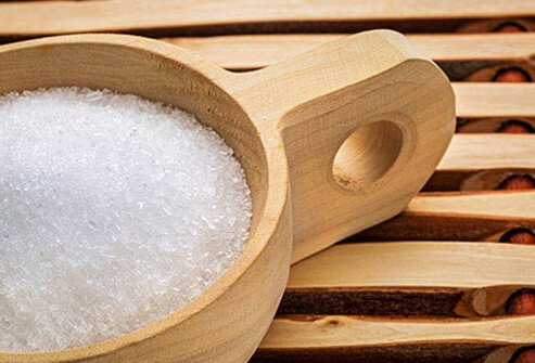 Salt grains in a wooden cup.