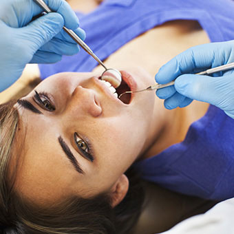 A woman receives a dental exam.
