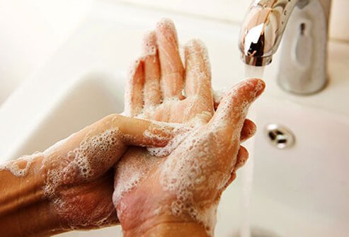 Hands being washed in a sink.