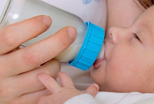 Close-up baby drinking from a bottle.