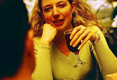 Photo of woman drinking wine in restaurant.