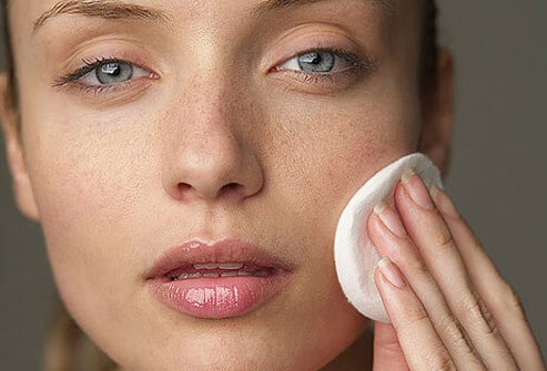 Photo of woman removing makeup.