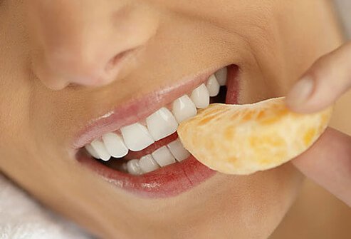 Photo of woman eating orange.