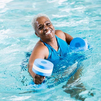 A woman performs water exercises in the pool to help with sacroiliac (SI) joint pain.