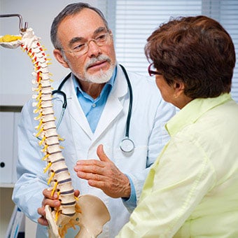 A doctor explains causes of sacroiliac (SI) joint pain to a patient.