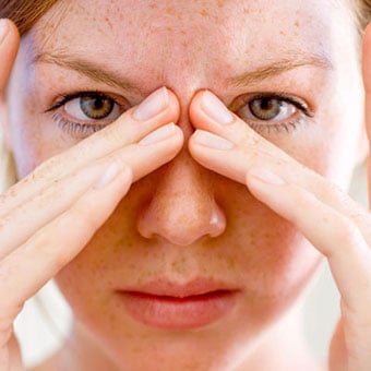 A woman in pain with a sinus headache.