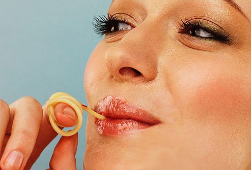 Photo of woman slurping spaghetti noodle.