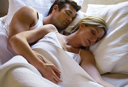 Spooning is a side sleeping position for couples. The person in the back holds the one in the front close to their body.
