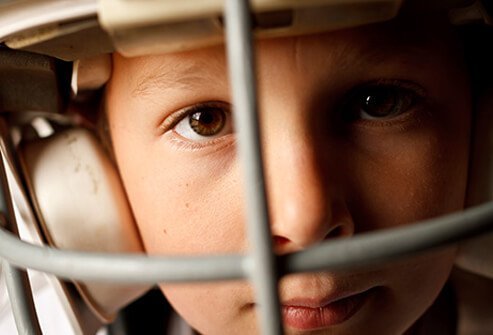 A boy wearing a football helmet.