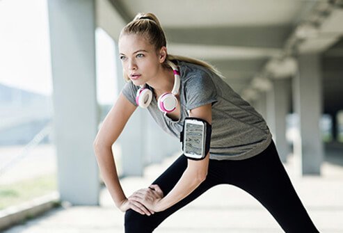 A young female stretching outdoors before exercising.