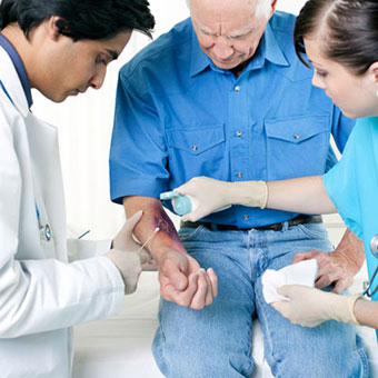 A doctor and nurse check for staph on a male patient's arm.