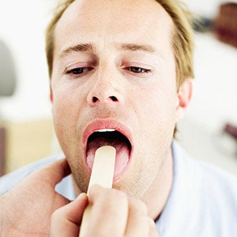 A man having his sore throat examined.