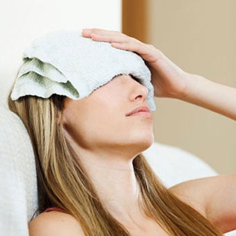 A woman uses a warm compress to relieve and treat a sty.