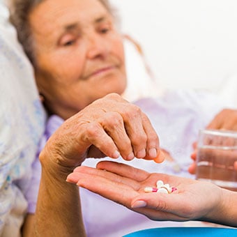 A nurse holds a medication bottle and  explains treatment to patient.
