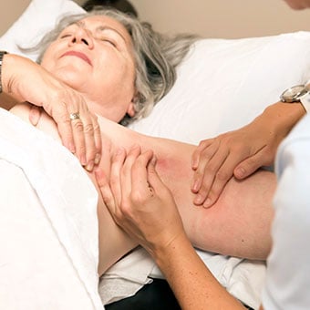 A photo of a woman undergoing an unpleasant lymph node under-arm exam.