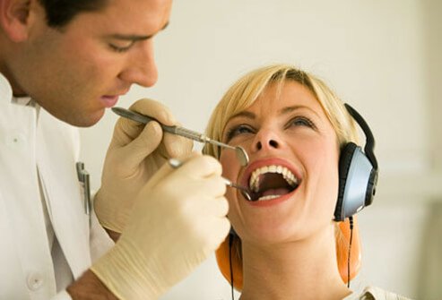 A dentist examining a woman's teeth.