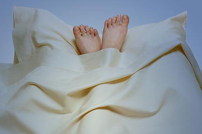 Apply a moisturizing shea butter cream or a healing ointment on your hands and feet before bed.