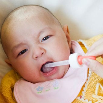 A baby is given antifungal drops to treat thrush.