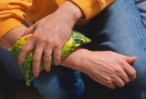Photo of a man icing sore joint.