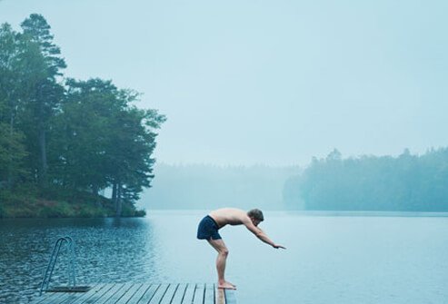 Photo of a man diving into a lake.
