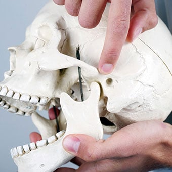 TMJ syndrome can manifest as pain and swelling in the jaw joint and surrounding facial muscles.
