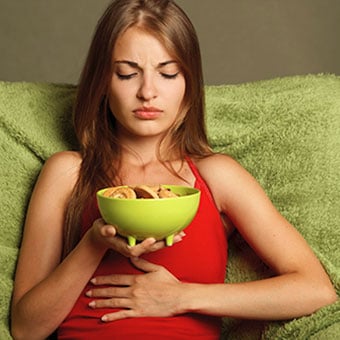 A female exeperiences constipation pain after eating.