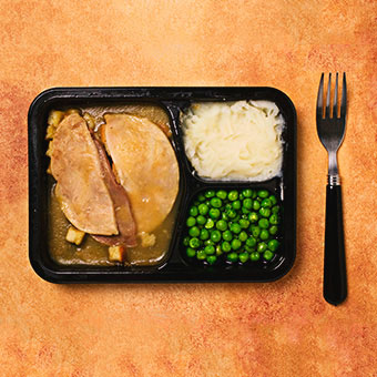 A frozen dinner of turkey, potatoes, and peas.