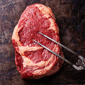 A raw cut of ribeye steak.