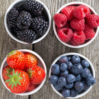 Bowls of blackberries, raspberries, strawberries, and blueberries.