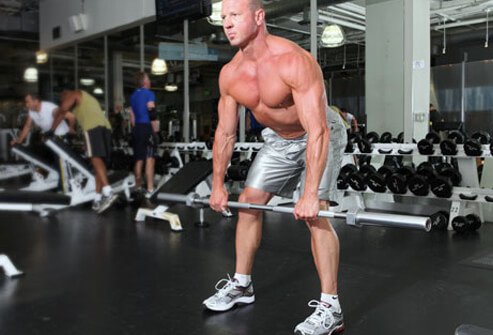 Photo of a trainer doing a Romanian dead lift with a barbell.