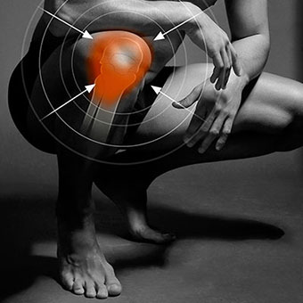 Black and white photo of a man with knee pain highlighted in red.