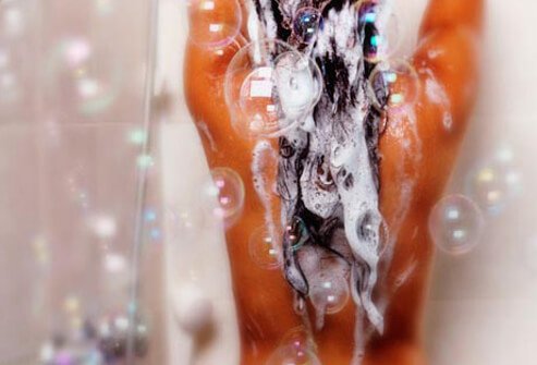 Photo of woman shampooing hair shower.