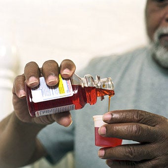 A man takes cough medication (antitussives) to reduce the cough of his upper respiratory infection.
