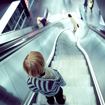 A view from the top of an escaltor warps, giving a feeling of vertigo.