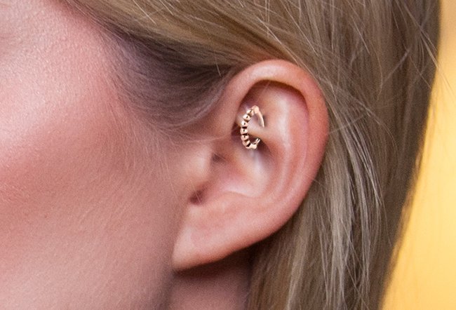 A rook piercing is done through the inner edge of the uppermost ridge in your ear.